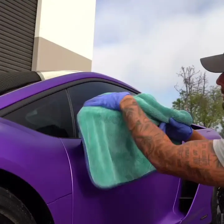 Hand drying a Porsche with a microfiber towel